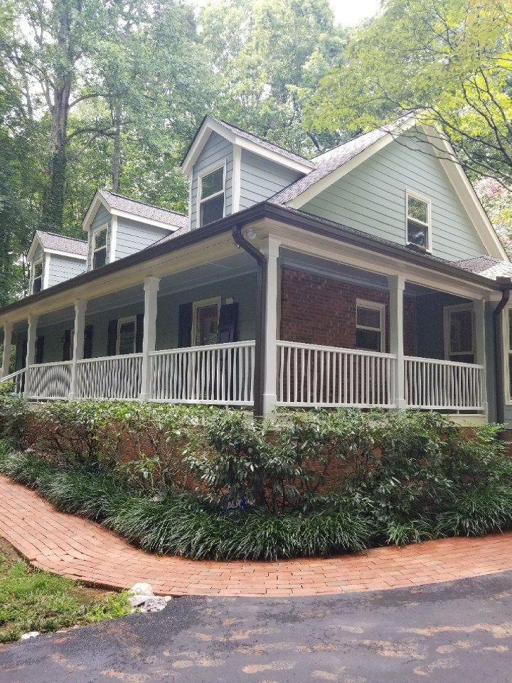 Home exterior after a facelift with new siding, windows and a front porch